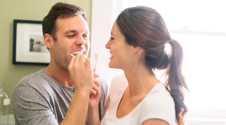 Mann und Frau beim Zähneputzen
