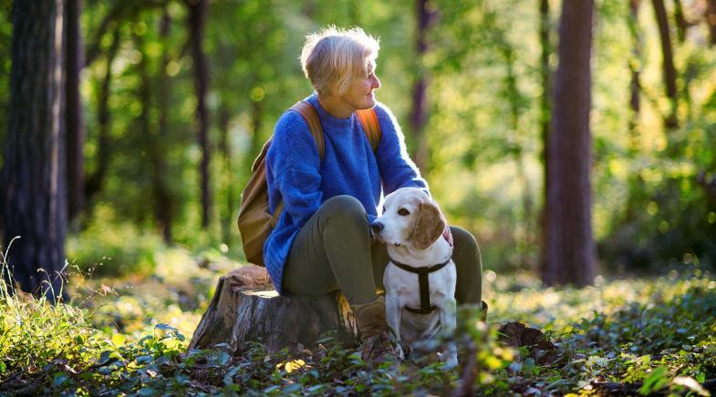 Rentnerin mit Hund im Wald