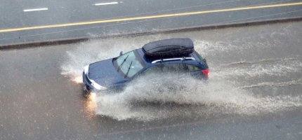 Auto fährt über eine wasserbedeckte Straße