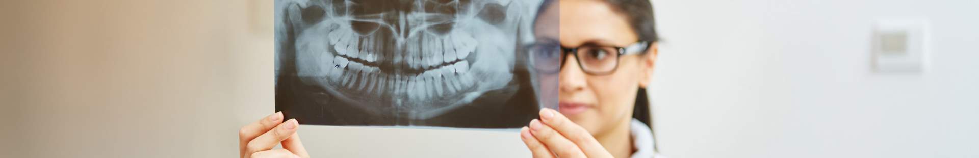 Zahnärztin schaut sich Röntgenbild an