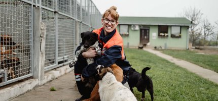 Frau mit Hunden vor einem Tierheim
