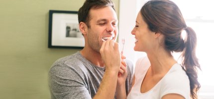 Mann und Frau putzen Zähne
