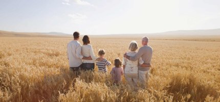 Familie – 3 Generationen – schaut auf ein Feld