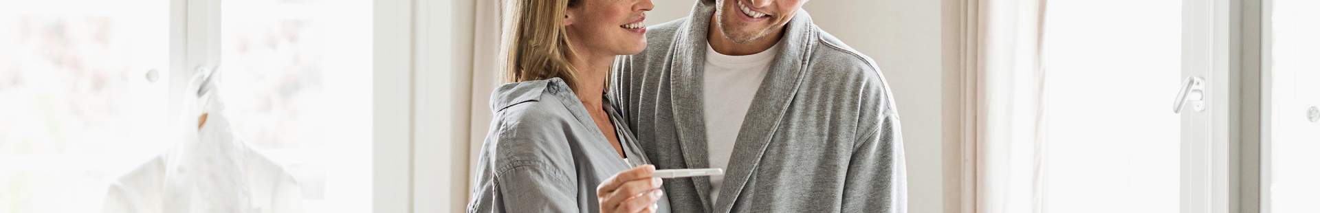 Mann und Frau schauen auf einen Schwangerschaftstest