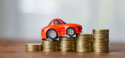Kleines Auto und Geldstapel