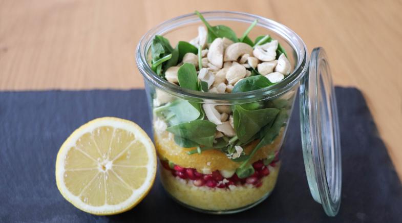 Couscous-Salat im Glas neben Zitrone