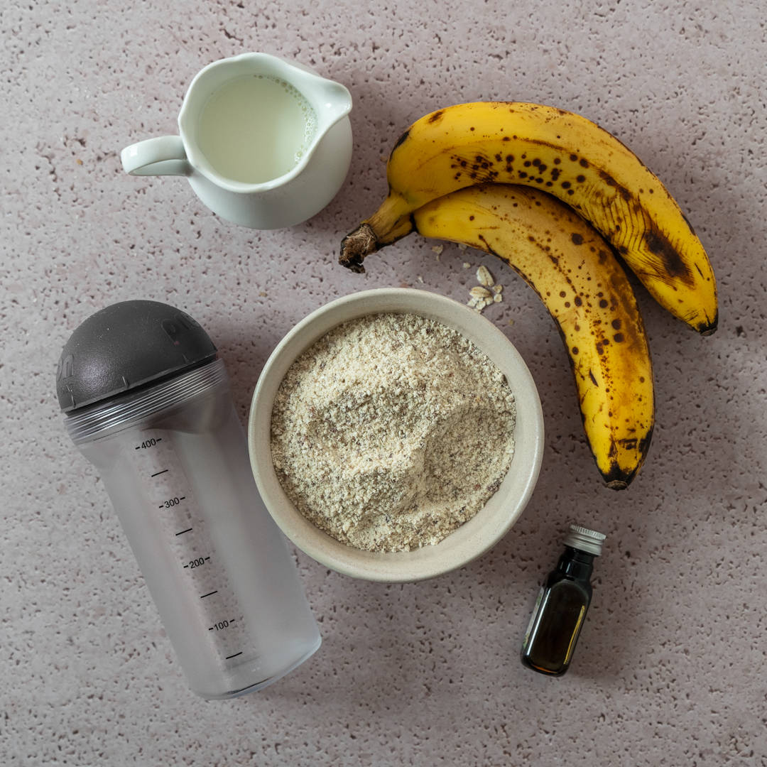Schritt 2: Bananen, Milch und Sirup neben Proteinpulver-Mix