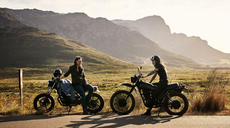 Zwei Motorradfahrer vor Bergen