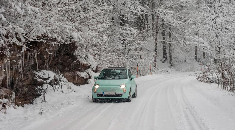Kleinwagen fährt auf zugeschneiter Straße