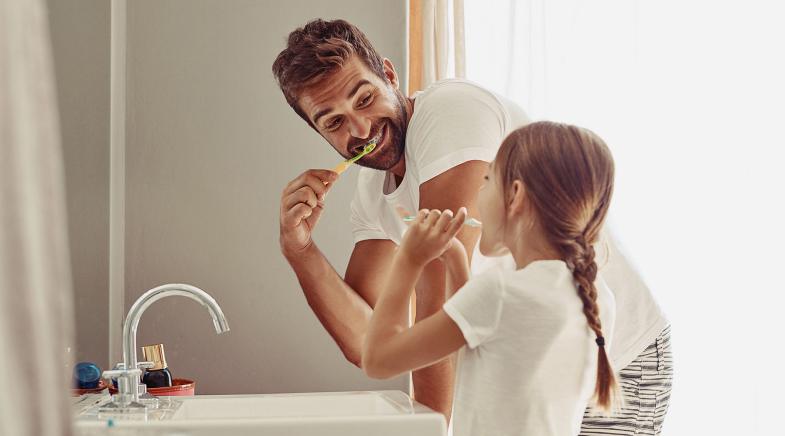 Vater und Tochter putzen Zähne