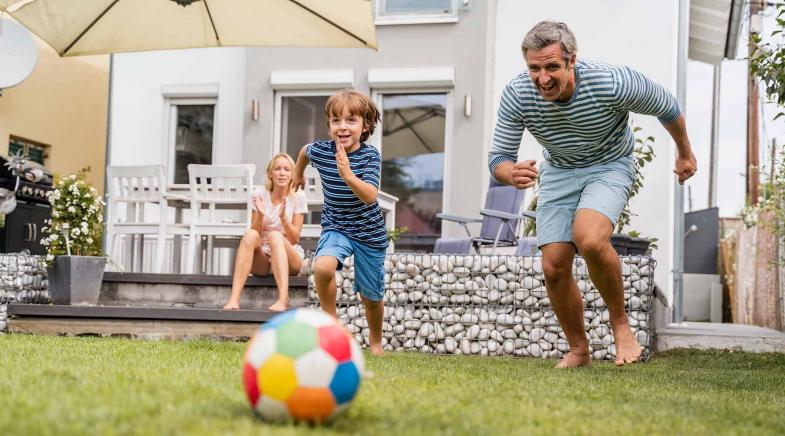 Familie im Garten spielen Frisbee