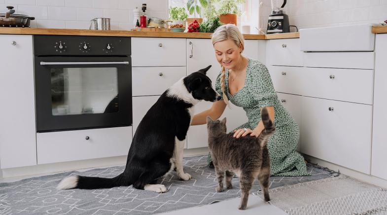 Frau mit Hund und Katze in Küche