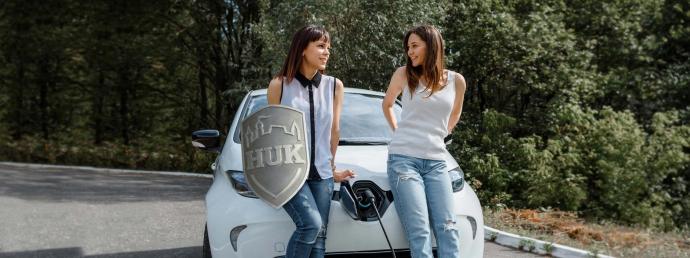 Zwei Frauen vor einem ladenden Elektroauto