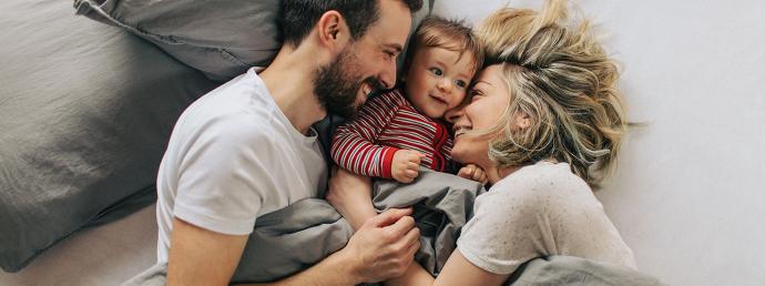 Familie im Bett eingekuschelt